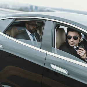 bodyguards-and-businessman-sitting-in-a-black-car.jpg