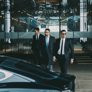 businessman-and-two-bodyguards-walking-to-car.jpg